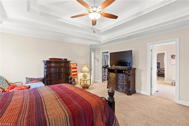 carpeted bedroom with a tray ceiling, ceiling fan, and crown molding