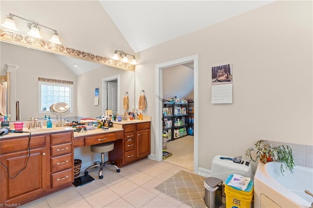 bathroom featuring lofted ceiling, vanity, a tub, and tile patterned floors