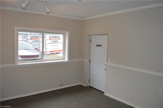 spare room with ornamental molding, unfinished concrete flooring, and baseboards