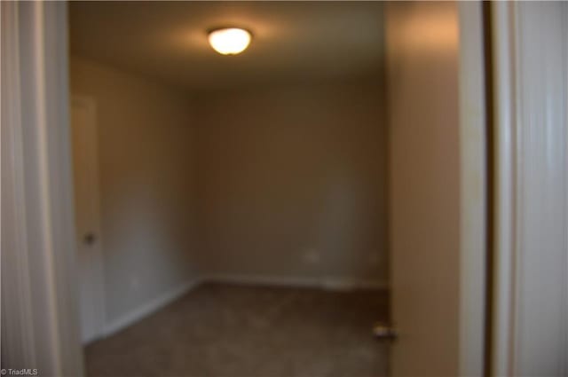 empty room featuring carpet floors and baseboards