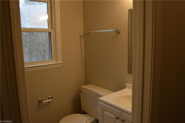 half bath featuring vanity and toilet