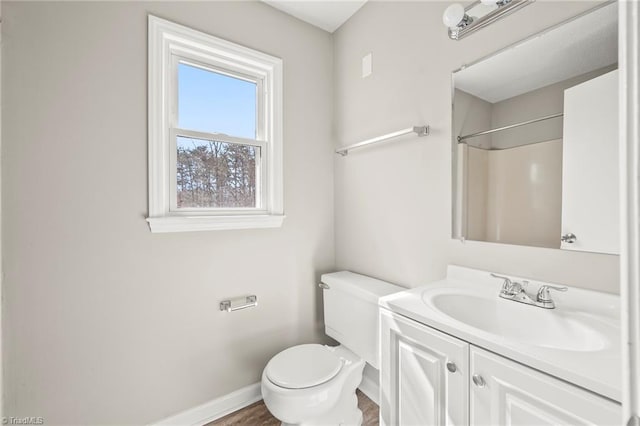 bathroom with vanity, toilet, and baseboards