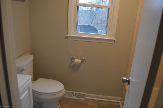 bathroom featuring toilet, baseboards, visible vents, and vanity