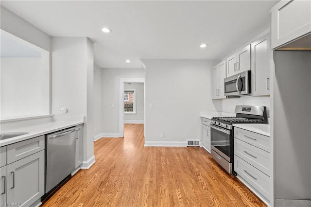 kitchen featuring light hardwood / wood-style floors, white cabinetry, and stainless steel appliances