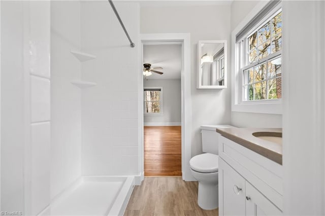 bathroom featuring walk in shower, vanity, ceiling fan, wood-type flooring, and toilet