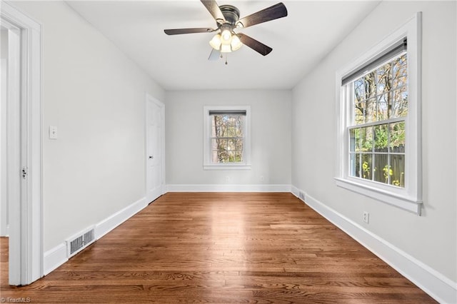 unfurnished room featuring ceiling fan, hardwood / wood-style floors, and a healthy amount of sunlight