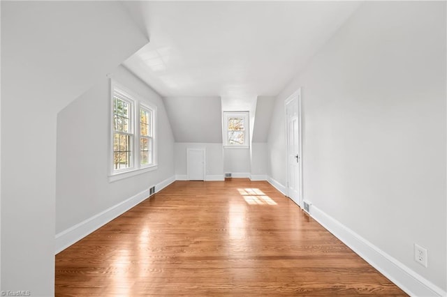 bonus room featuring lofted ceiling and light hardwood / wood-style flooring