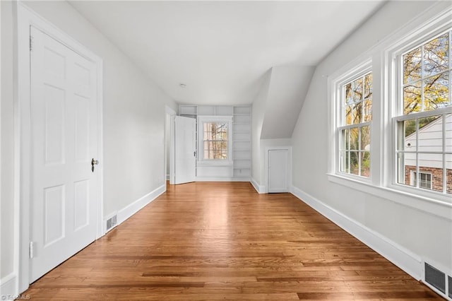 bonus room with hardwood / wood-style floors, vaulted ceiling, and a wealth of natural light