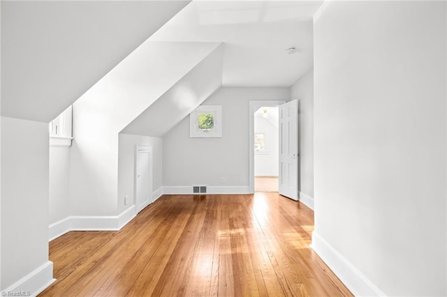 additional living space with light hardwood / wood-style flooring