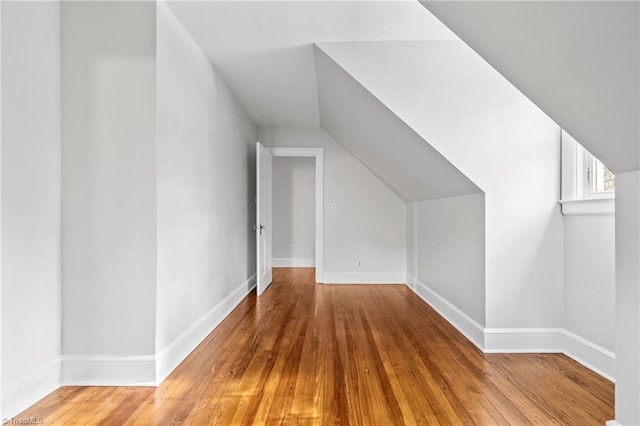 additional living space featuring wood-type flooring and lofted ceiling