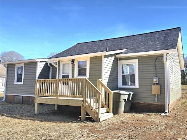 back of house with a shingled roof and a wooden deck