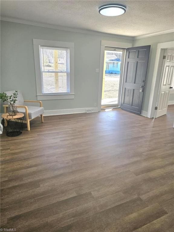 foyer featuring ornamental molding, dark wood-style flooring, a textured ceiling, and baseboards