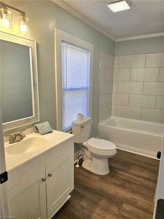 bathroom with toilet, wood finished floors, vanity, tub / shower combination, and crown molding