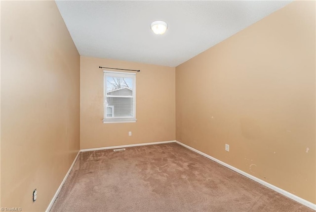 carpeted empty room featuring visible vents and baseboards