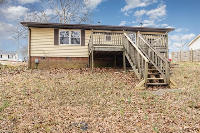 rear view of property with crawl space, stairway, a wooden deck, and fence