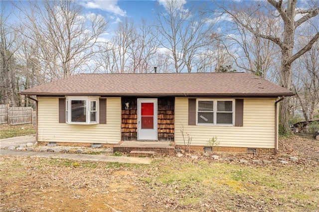 ranch-style house with a shingled roof, fence, and crawl space