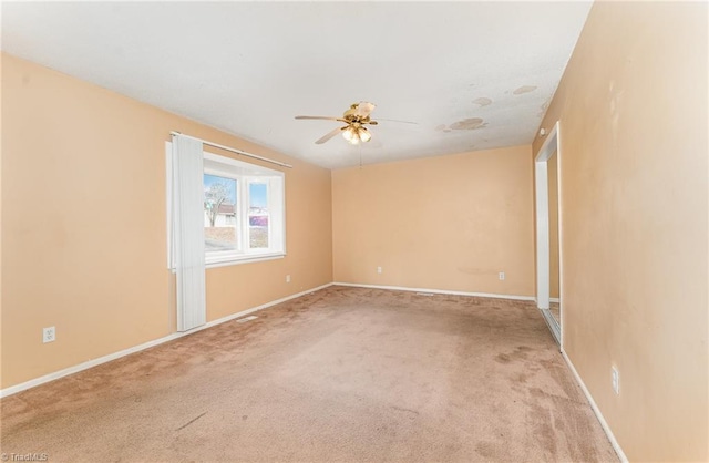 spare room with baseboards, carpet floors, and a ceiling fan