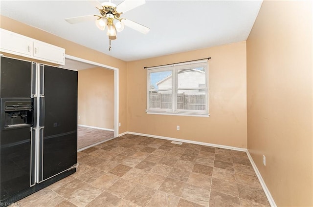 empty room featuring baseboards and ceiling fan