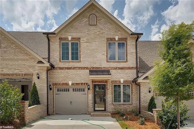 traditional home with a garage, brick siding, and driveway