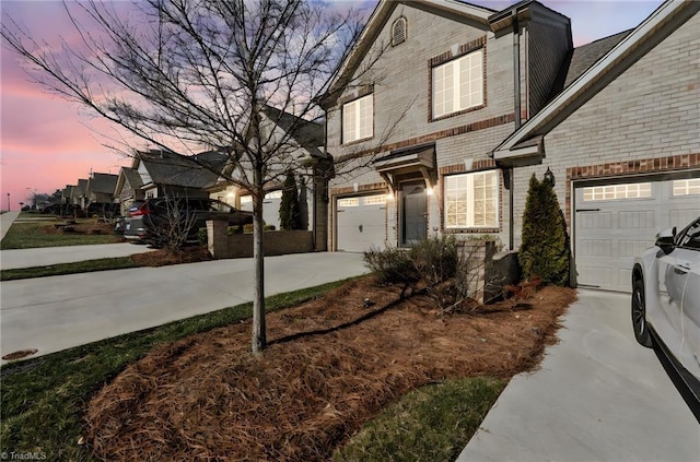 view of front of home featuring concrete driveway and brick siding