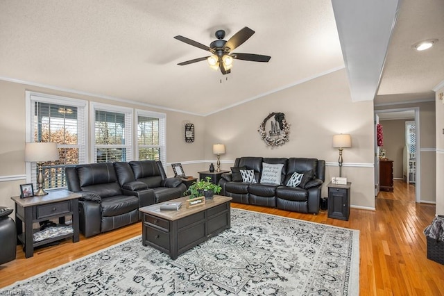 living room featuring hardwood / wood-style flooring, ceiling fan, and crown molding