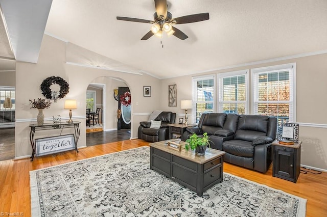 living room featuring vaulted ceiling, light hardwood / wood-style flooring, ceiling fan, and ornamental molding