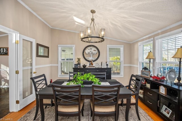 dining room with light wood-type flooring, ornamental molding, and a chandelier