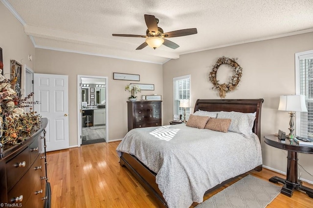 bedroom with connected bathroom, ceiling fan, light hardwood / wood-style flooring, vaulted ceiling, and a textured ceiling