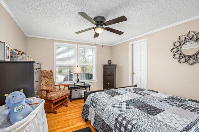 bedroom with hardwood / wood-style flooring, ceiling fan, ornamental molding, and a textured ceiling