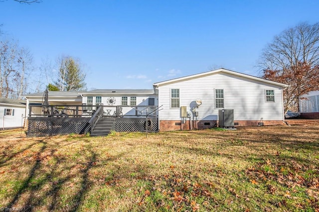 rear view of house featuring central AC unit, a deck, and a yard