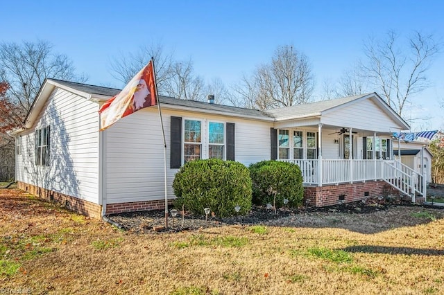 view of side of property featuring ceiling fan, covered porch, and a yard