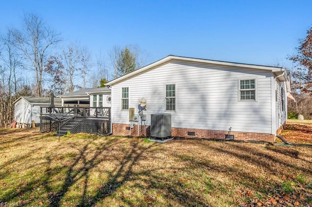 back of property featuring a lawn, a wooden deck, and central AC unit