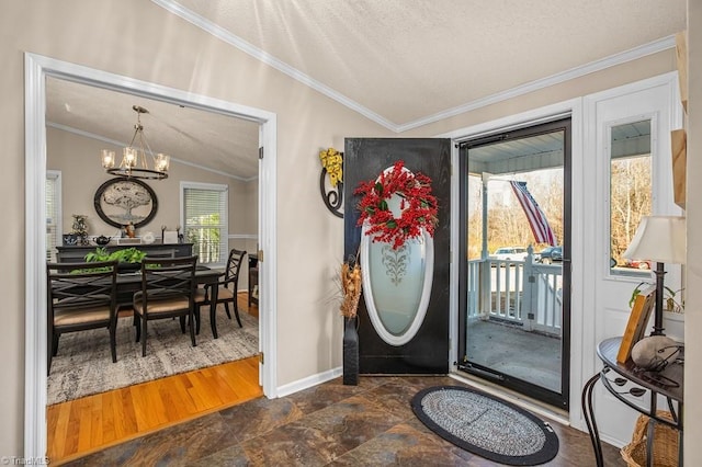 entryway with a textured ceiling, crown molding, vaulted ceiling, and an inviting chandelier