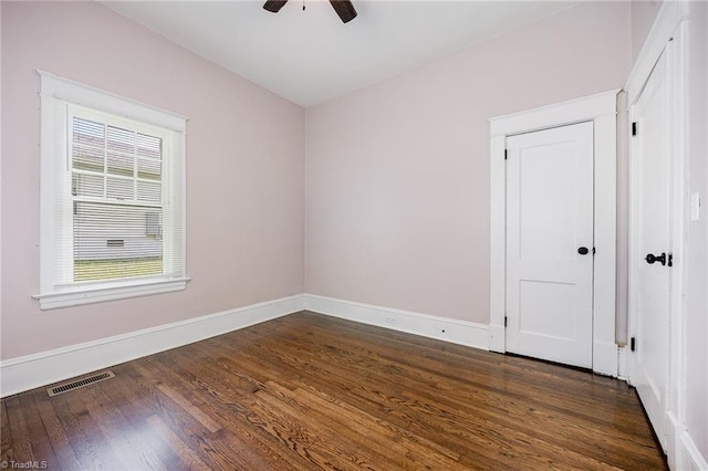 spare room with dark wood finished floors, baseboards, and a ceiling fan