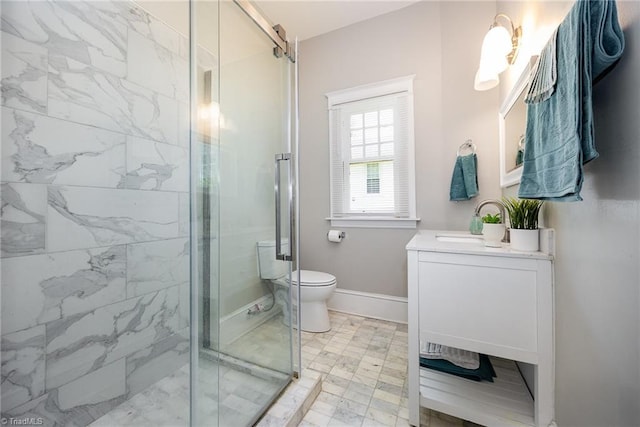 bathroom featuring a stall shower, vanity, toilet, and baseboards