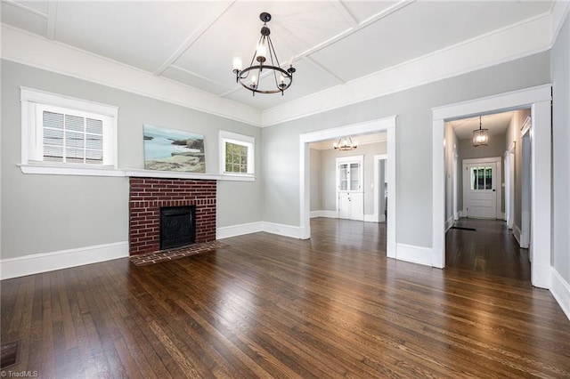 unfurnished living room with a chandelier, hardwood / wood-style flooring, and baseboards