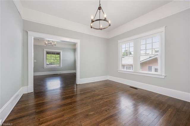 unfurnished room with a chandelier, dark wood-type flooring, and baseboards