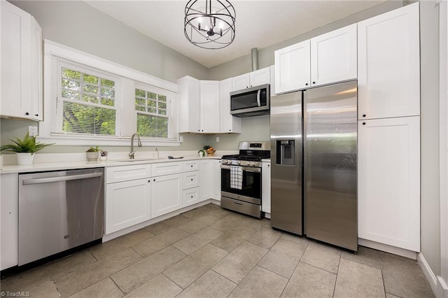 kitchen with stainless steel appliances, a sink, a chandelier, and light countertops