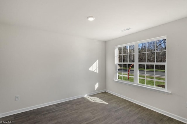 empty room with plenty of natural light and dark hardwood / wood-style flooring