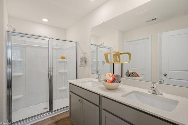 bathroom featuring hardwood / wood-style flooring, a shower with door, and vanity