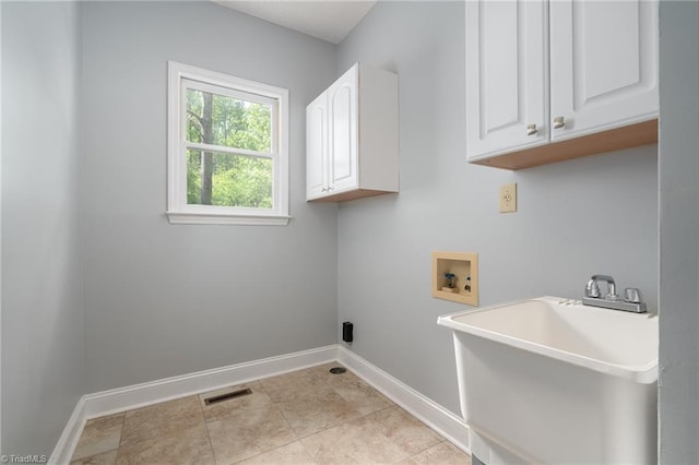 laundry room with a sink, cabinet space, washer hookup, visible vents, and baseboards