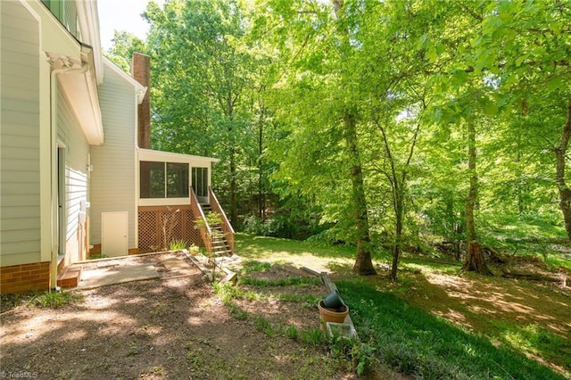 view of yard with stairway and a sunroom