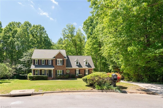 colonial house with a front yard and brick siding