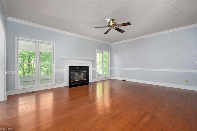 unfurnished living room with wood finished floors, ceiling fan, baseboards, visible vents, and a fireplace with flush hearth