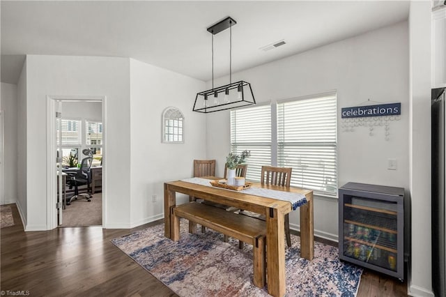dining room featuring wine cooler, baseboards, wood finished floors, and visible vents