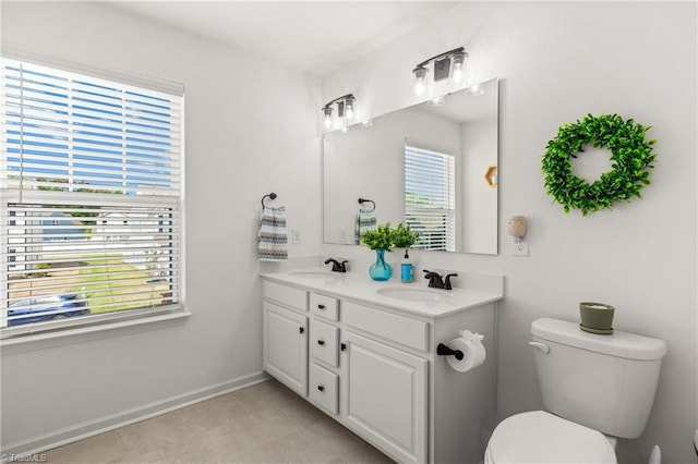 full bath featuring a sink, baseboards, toilet, and double vanity