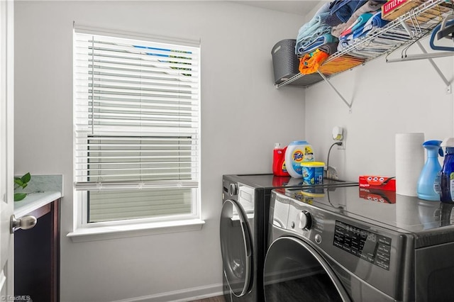 washroom with baseboards, laundry area, and washer and clothes dryer