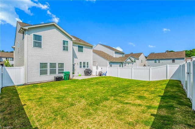 back of property featuring a fenced backyard, a patio area, and a yard