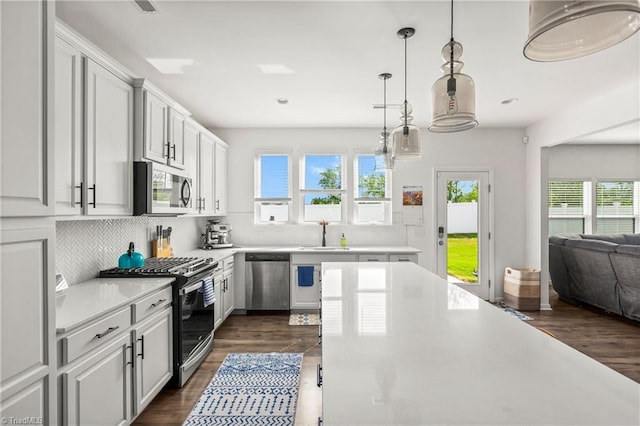 kitchen with tasteful backsplash, light countertops, a sink, stainless steel appliances, and recessed lighting