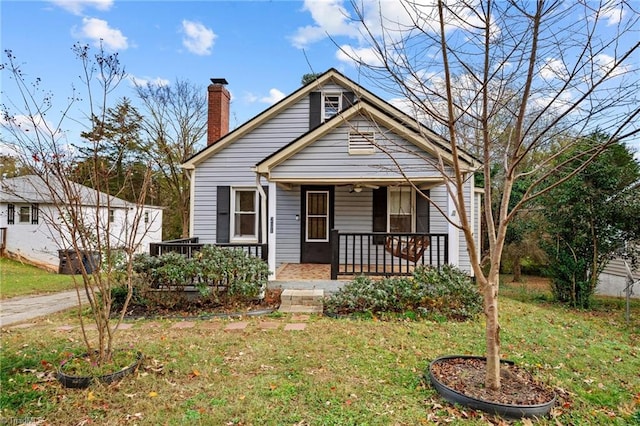 bungalow-style home with covered porch and a front yard